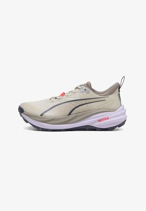 Chaussure de sport beige clair avec des accents gris, une semelle blanche épaisse étiquetée "NITRO," et une languette noire au talon.