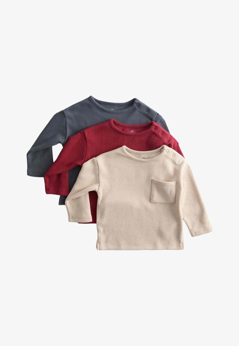Tre langærmede ribbede toppe i mørkegrå, rød og creme. Den cremefarvede top har en lille brystlomme og trykknapper i siden.