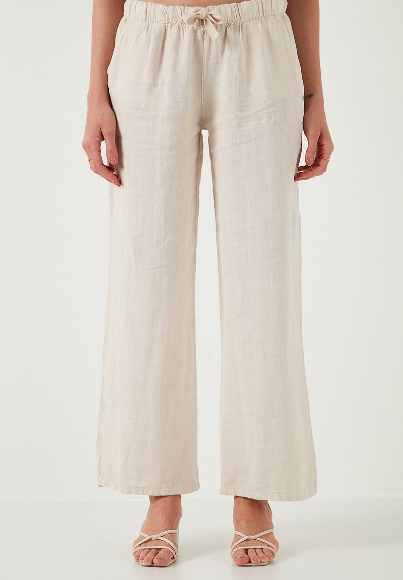 Beige, wijde broek van linnen met een elastische tailleband en verstelbaar trekkoord. Soepele textuur en nette zoomafwerking.