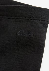 Mustad must sok, millel on peen ribimine ja sile tekstuur, ning millega on kokku saanud tikitud "Clarks" logo sobivas mustas niidis.