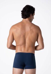 Boxer shorts blu navy realizzati in tessuto morbido e elasticizzato. Presentano un elastico in vita liscio e un design aderente, visibile da dietro.