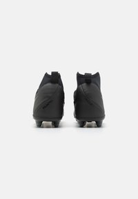 Svarta fotbollsskor med en slät syntetisk ovandel, sock-liknande krage och formade dobbar för grepp. Varumärkeslogotyp synlig på sidan.