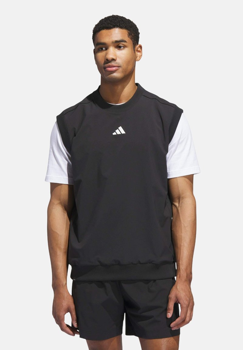 Schwarzes ärmelloses Sportoberteil mit runder Halslinie, versehen mit einem weißen Logo. Kombiniert mit schwarzen Shorts, beide aus glattem Stoff.