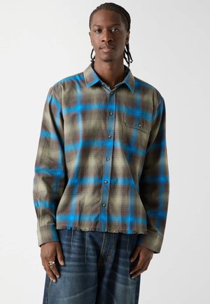 Kariertes Flanellhemd zum Knöpfen in Olivgrün und Blau, mit Brusttasche, leicht ausgefranstem Saum und entspannter Passform.