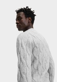 Hellgrauer, kabelgestrickter Pullover mit strukturiertem Muster, runder Halslinie und langen Ärmeln, hergestellt aus einem weichen, gemütlichen Material.