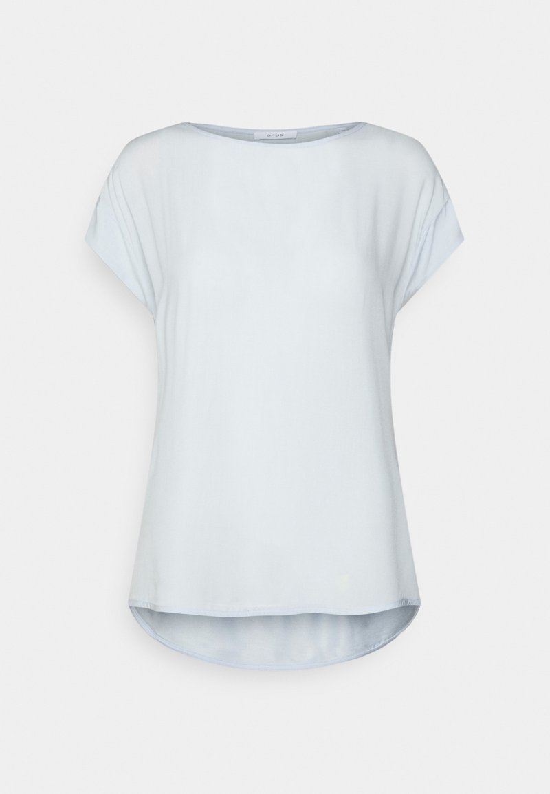 Blouse bleu clair à manches courtes, encolure ronde et ourlet incurvé légèrement plus long à l'arrière.