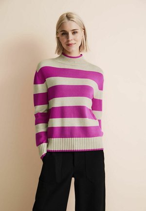 Pull-over rayé en rose et beige, avec un col haut et des manches longues. Poignets et bas en côte. Tissu doux avec une coupe décontractée.