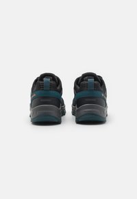 Czarne i turkusowe wodoodporne sneakersy z teksturowaną siateczką u góry, kontrastującymi akcentami na pięcie i szarymi podeszwami. Posiadają wyraźne logo i pętelkę do zakładania.