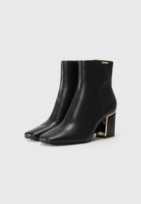 Black leather ankle boots with a square toe and a chunky heel featuring a gold accent detail. Smooth texture and streamlined design.