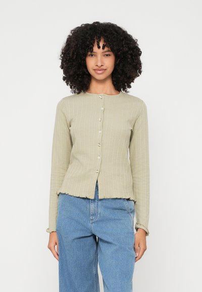 Cardigan à manches longues en ribbed de couleur vert clair avec un col rond et de petits boutons. Présente un ourlet festonné et une silhouette ajustée.