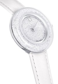 Montre ronde en argent avec un cadran texturé scintillant, bracelet en cuir blanc et indices horaires simples. Dispose d'une lunette métallique lisse et de la mention Swiss Made.