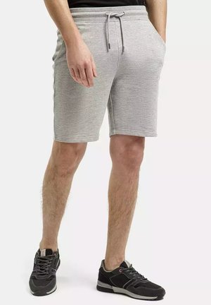 Szare szorty bawełniane z elastycznym paskiem, sznurkiem i kieszeniami po bokach. Połączone z czarnymi butami sportowymi.