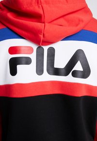 Sweat à capuche avec des blocs de couleurs rouge, bleu, blanc et noir et un grand logo FILA au dos.