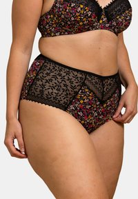 Ensemble de lingerie noire avec des motifs floraux en rose, jaune et blanc, avec des accents en dentelle sur le short et une texture lisse.