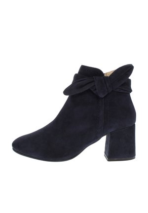 Schwarzer Wildleder-Stiefelette mit Blockabsatz und dekorativem Schleifendetail um den Knöchel, von der Außenseite gezeigt.