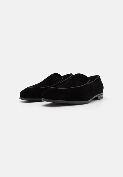 Schwarze Wildleder-Schlüpfschuhe mit glatter Oberfläche, abgerundeter Zehenpartie und minimalistischem Design. Verfügt über einen niedrigen Absatz und keine sichtbare Hardware.