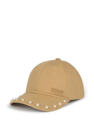 Gorra de béisbol beige con logo "TOUS" bordado y perlas blancas decorativas a lo largo del borde de la visera curva.