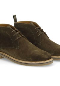 Bottines chukka en daim marron avec une texture lisse, dotées d'un bout arrondi, d'un laçage à l'avant et d'une semelle en caoutchouc contrastante avec des coutures visibles.