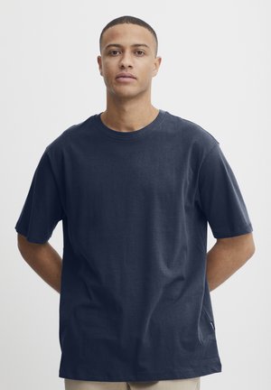 Marineblå crewneck t-shirt med korte ærmer i blødt stof, der har en afslappet pasform og minimale sømdetaljer, uden synlige logoer eller mønstre.