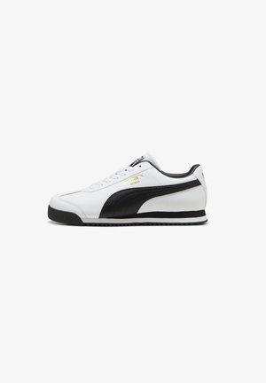 Puma Roma kedas baltā ādas ar melniem akcentiem, ar teksturētu augšējo daļu, auklu aizdari un gumijas zoli ar melniem malām.