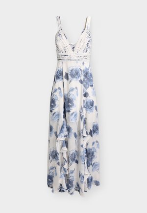 Λευκό μακρύ φόρεμα με μπλε λουλουδένιο σχέδιο, κορσέ με V-λαιμόκοψη δαντέλα και βολάν στο φουστάνι, χωρίς μανίκια με τιράντες στους ώμους.