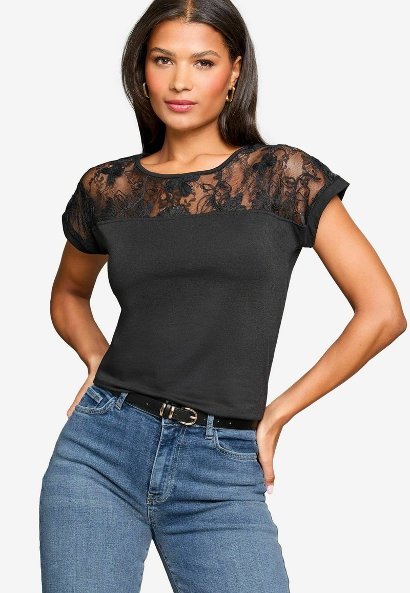 Must have must-haves ju black paheline T-särk, millel on õhuline pitsi yoke lillemotiividega, lühikesed varrukad ja vormihoidev disain. Ühendatud siniste teksade ja musta vöödiga.