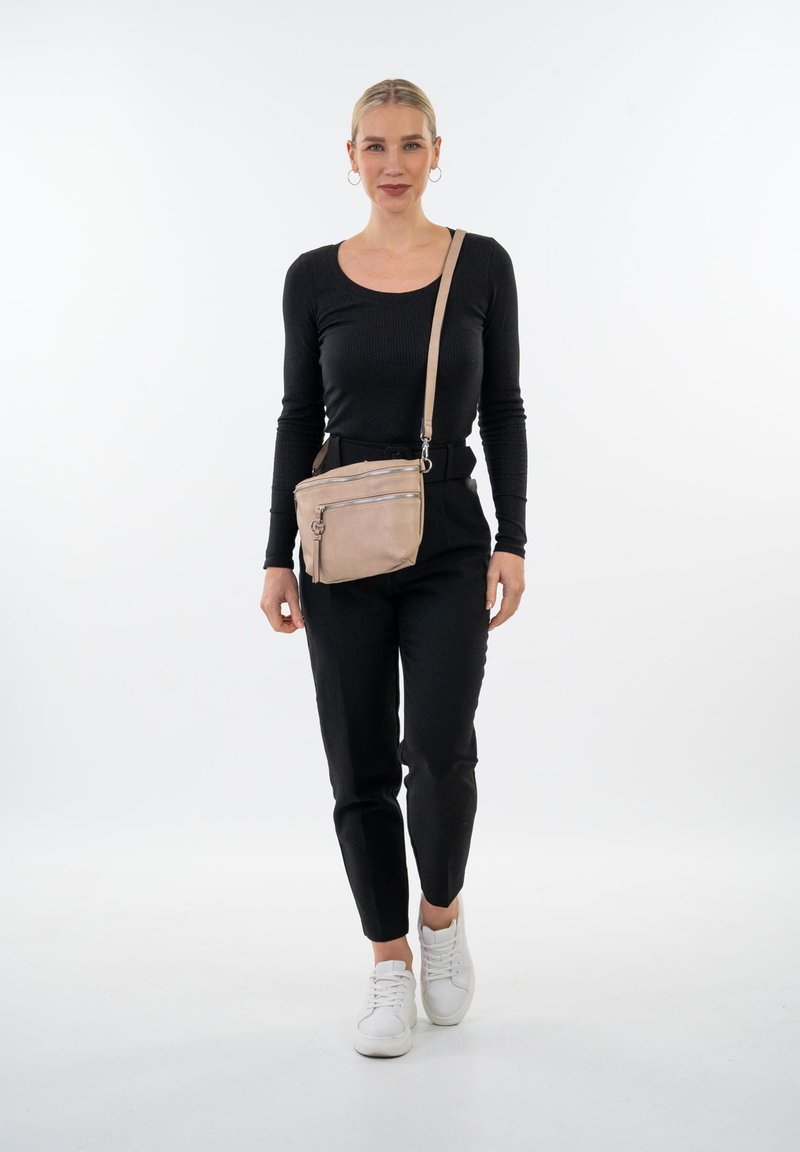 Crossbody taske i blødt beige læder med to lynlåslommer. Minimalistisk design, rektangulær form og justerbar rem for komfort.