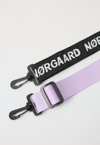 Två remmar: en svart med vit text "NØRGAARD" och en lavendel. Båda har plastklipp och krokar, tillverkade av vävd tyg.