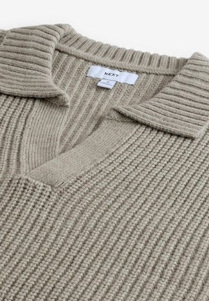 Beige knitted sweater with a ribbed texture, featuring a V-neck and a flat collar. The fabric appears soft and warm. Brand label visible.