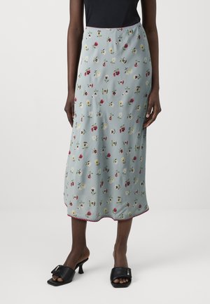 Light blue floral skirt with small, colorful flower patterns. Features a hem with contrasting stitching. Model paired with black slide heels.