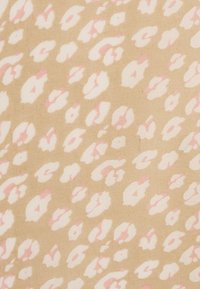 Tela beige con un patrón de estampado de leopardo en rosa suave y blanco, con formas irregulares y una superficie texturizada.