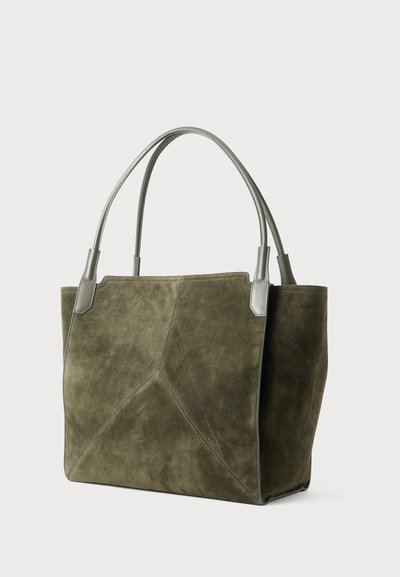 Geantă de umăr din suede de culoare verde măslinie, cu mânere din piele gri netedă, detalii geometrice pe cusături și design deschis la vârf. Formă rectangulară cu laturi bine definite.
