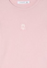 T-shirt di cotone rosa con un piccolo orsetto ricamato in rosa più chiaro, scollatura rotonda e texture a coste. Etichetta di taglia S visibile.