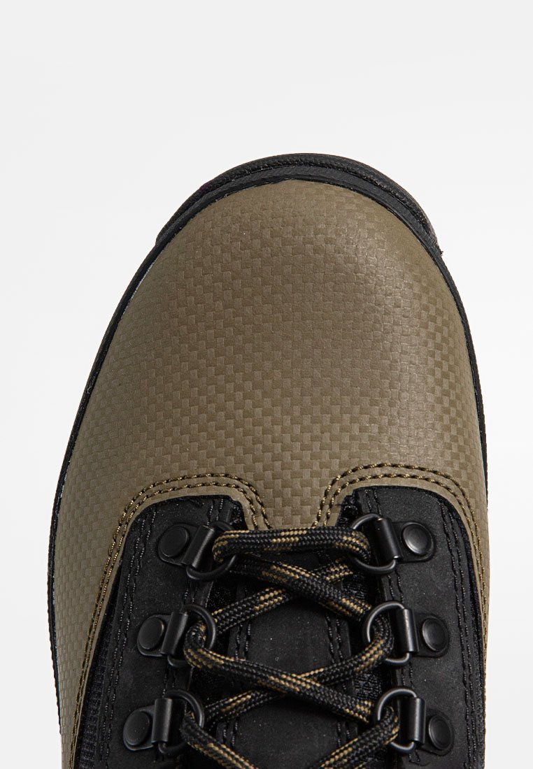 Buty trekkingowe w kamuflażu z teksturowaną, brązową cholewką, czarnymi skórzanymi akcentami, metalowymi oczkami i wytrzymałymi sznurowadłami. Wzmocniony design czubka.