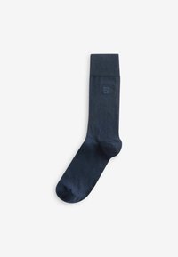 Calcetín de algodón azul marino con puño acanalado, textura suave y un pequeño detalle de logo cerca de la parte superior. Diseño simple y clásico.