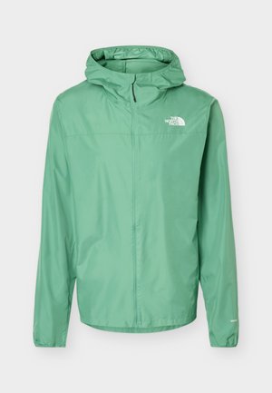 Chaqueta impermeable con capucha de color verde claro, con cremallera frontal completa y logo de The North Face en el pecho.