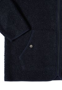 Granatowa polarowa kurtka z teksturowanej tkaniny, z zapięciem na zamek, bocznymi kieszeniami i kontrastowym wykończeniem na krawędziach.