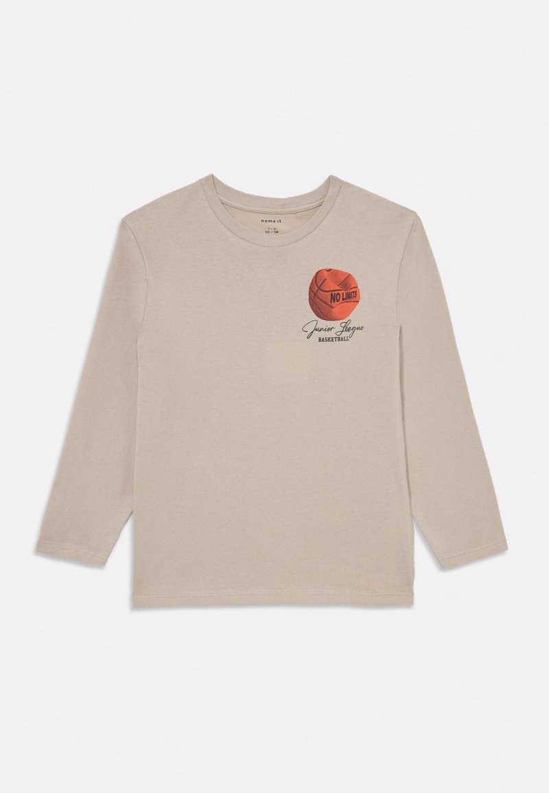 Μπεζ μπλούζα μακρυμάνικη από βαμβάκι, με γραφικό κόκκινου μπάσκετ που φέρει το κείμενο "NO LIMITS" και την ένδειξη "Junior League Basketball" από κάτω.