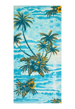 Ręcznik plażowy z niebieskimi falami oceanu, palmami, tropikalnymi kwiatami oraz białym logo Quiksilver po prawej stronie.