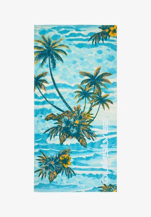 Ręcznik plażowy z niebieskimi falami oceanu, palmami, tropikalnymi kwiatami oraz białym logo Quiksilver po prawej stronie.