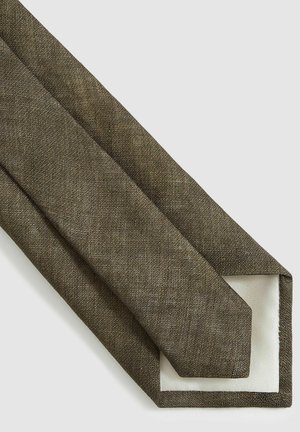 Cravate en lin marron avec une finition texturée et une doublure unie blanche cassé sur le dessous. Forme étroite et pointue pour un style classique.