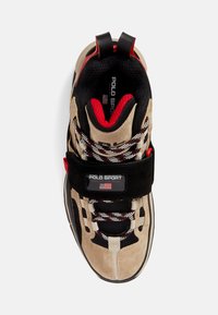 Beige and black Polo Sport sneaker with red accents, striped laces, mesh panels, and a black strap featuring the Polo Sport logo and flag.