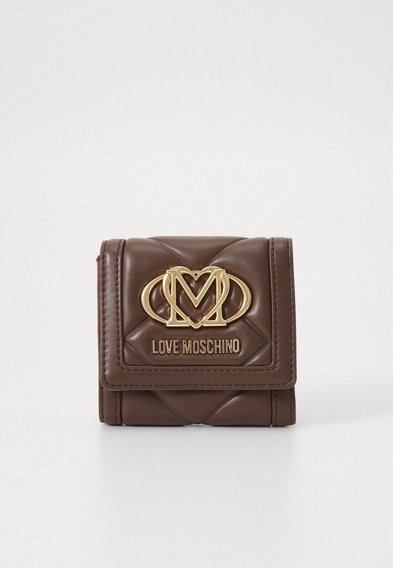 Ruskea keinonahkainen lompakko, jossa on tilkkutöitä muistuttava kuosi, kultasävyinen logo ja metalliosat sekä magneettinen napsulukko. Kompakti suorakulmainen muoto.