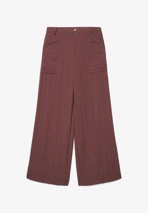 High-waisted wide-leg pants in textured dark mauve fabric with large front patch pockets and a button closure at the waistband.