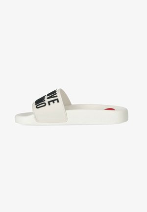Chausson à glissière blanc avec une large lanière portant les mots "LOVE" et "NO." Matériau en caoutchouc, semelle plate et texture lisse. Design simple.