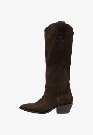 Botas de ante marrón hasta la rodilla con punta afilada, tacón apilado y acentos de costura. Presentan un lazo en la parte trasera para facilitar el calzado.