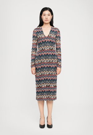 Long-sleeve, zigzag-patterned dress featuring multicolored stripes in blue, red, and beige, with a V-neckline and fitted silhouette.