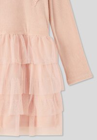 Sukienka z długim rękawem o prążkowanej górze w delikatnym różu, z warstwową spódnicą z tiulu składającą się z trzech falbaniastych warstw, co dodaje faktury i objętości.