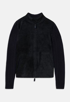 Black jacket with a smooth suede body and textured knitted sleeves. Features a high collar, zip closure, and side pockets.