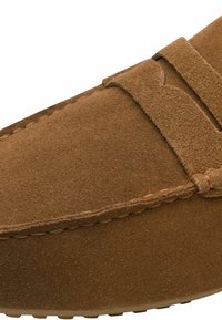 Καφέ μοκασίνι από σουέντ με ραφές και λουράκι στο πάνω μέρος, με στρογγυλεμένη μύτη και υφασμένη άκρη σόλας.